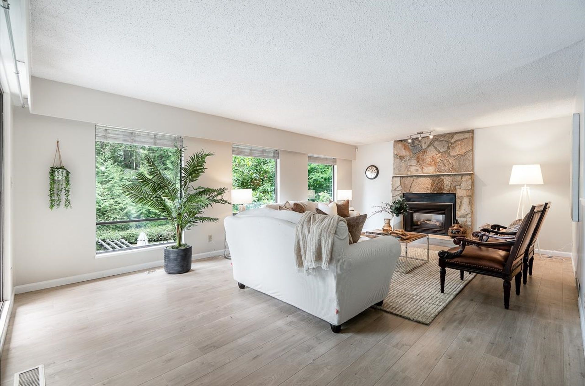 Family-friendly living space with fireplace and large windows overlooking nature at 1184 Riverside Drive, Seymour NV, North Vancouver
